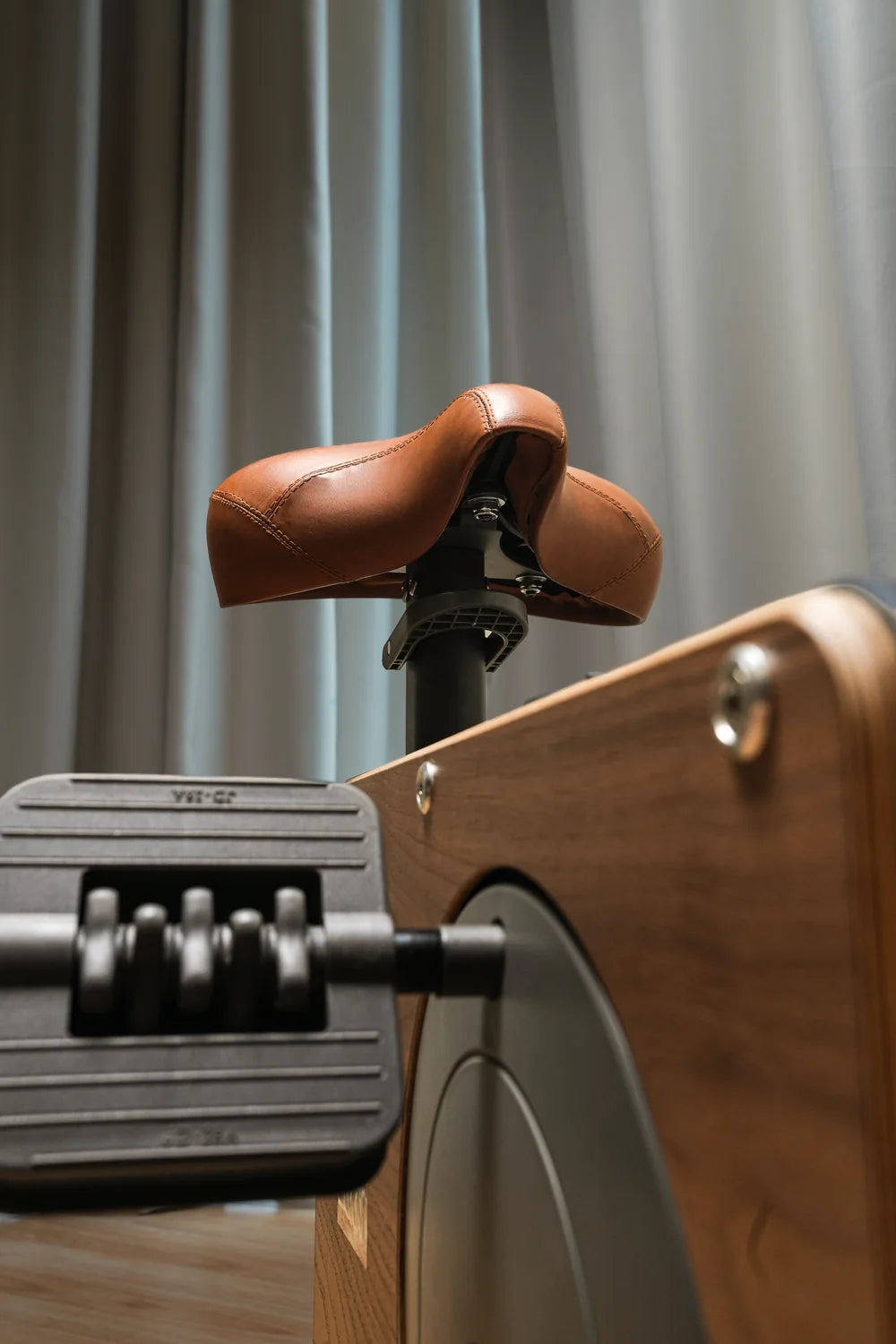 Low-angle photograph of the real Cube Cycle walnut finish and stitched seat